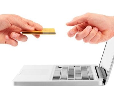 transactions vs relationships - photo of two hands exchanging cedit card through laptop screen