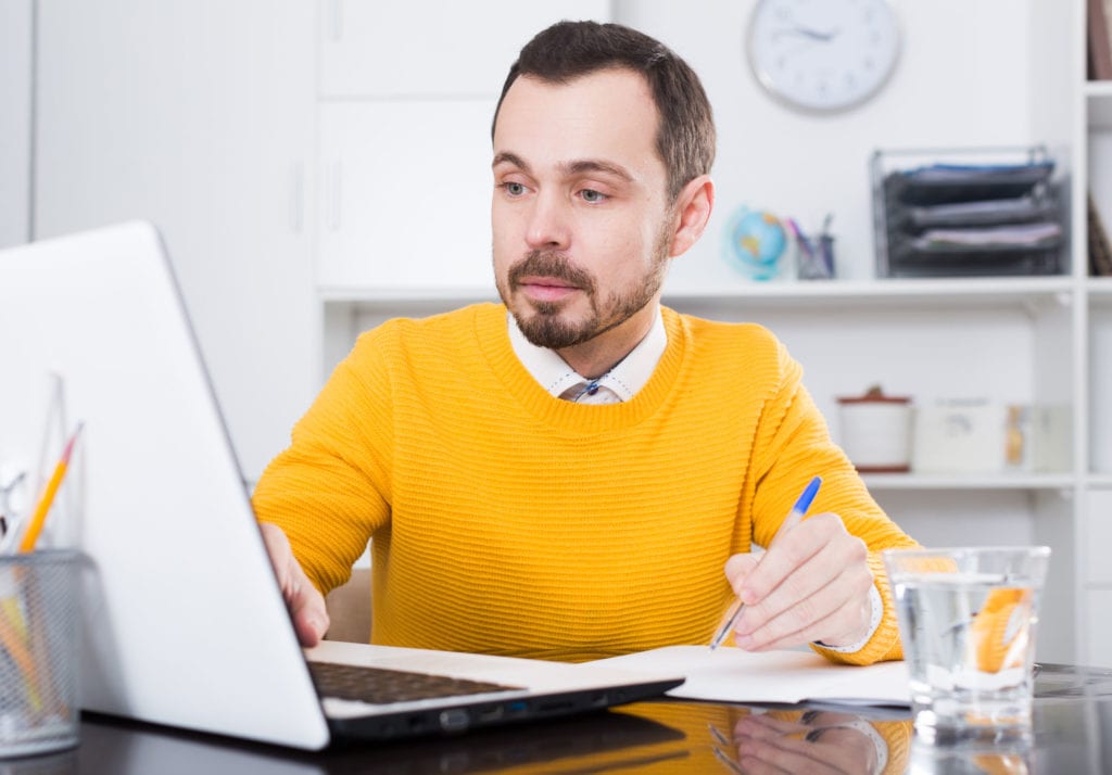 Photo of engaged adult male learner at laptop