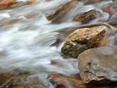 Photo of rocks in stream for learning as process concept