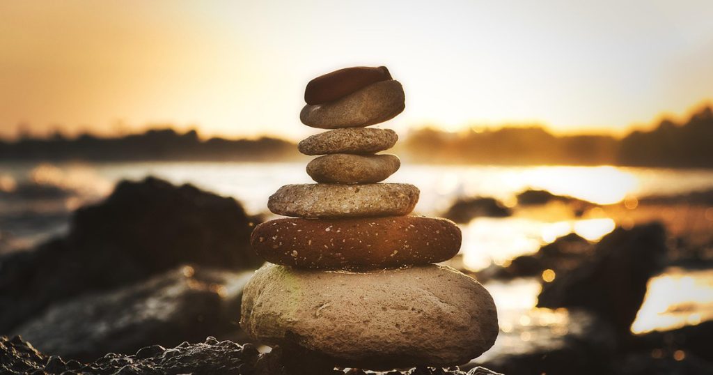 stacked stones in front of a sunset